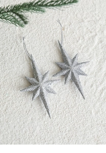 Close-up of sparkling silver glitter eight-point star ornaments with hanging strings