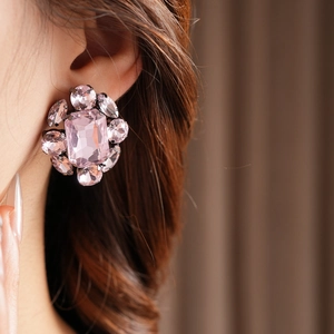 Détail d'un mannequin portant une boucle d'oreille vintage en cristal rose avec flocon