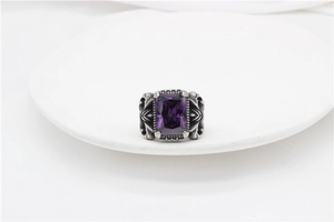 Detailed macro view of vintage gothic ring with large rectangular purple stone and carvings