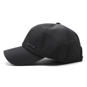 Detail view of black quilted men's winter cap with warm padding and metal men's logo tag
