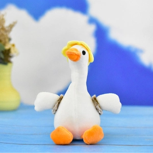 Vue rapprochée d'une adorable oie en peluche blanche avec un chapeau jaune et un bec orange