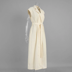 Detail of a beige sleeveless shirt dress featuring a lapel collar and waist tie belt