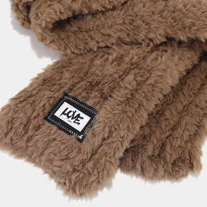Détail d'une écharpe en peluche marron avec fausse fourrure douce et écusson LOVE chic