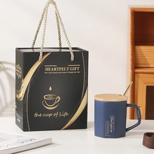 Blue ceramic mug gift set with wooden lid, golden spoon, and black gift box packaging