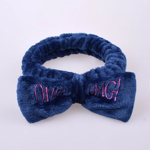 Detail of blue coral fleece headband showing soft texture and pink OMG embroidery