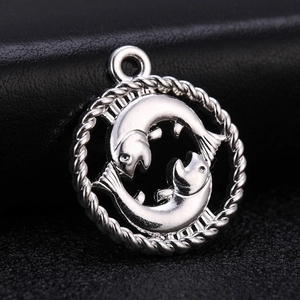 Macro detail of silver Pisces zodiac pendant with intricate fish design and rope border