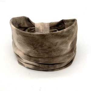 Close-up of wide tan headband with velvet texture and elastic fabric folds