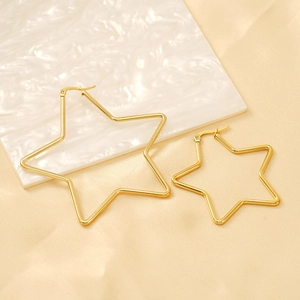 Boucles d'oreilles créoles étoiles dorées minimalistes en deux tailles sur fond marbre
