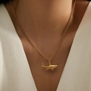 Minimalist 18k gold plated shark pendant necklace on a female model neck