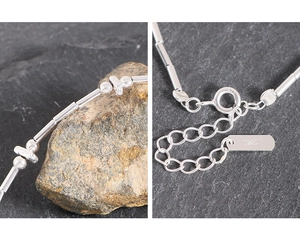Macro detail of S925 sterling silver minimalist bracelet with bead and tube links