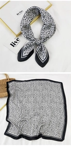 Detail of black and white leopard print silk scarf styled with fashion accessories
