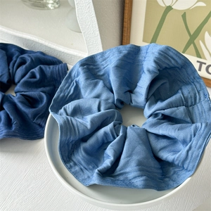 Detail of blue and dark blue denim fabric scrunchies with soft ruffled texture