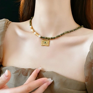 Dettaglio della collana vintage in perle di resina con ciondolo occhio portafortuna