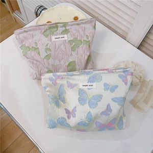 Close-up of floral and butterfly jacquard fabric texture on simple wish makeup bags