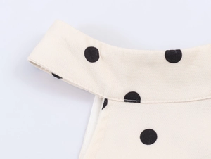 Détail du col licou et des bretelles sur une robe longue à pois beige à volants