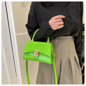 Detail of bright green crocodile pattern leather mini square bag with gold twist lock