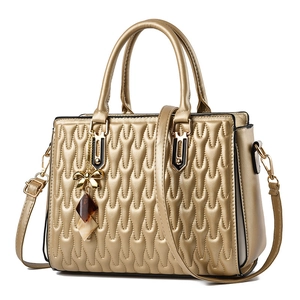 Elegant gold quilted tote bag with wave texture, dual handles and crossbody strap