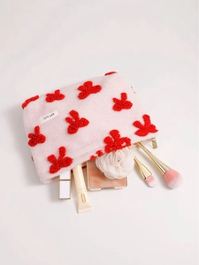 Pink plush cosmetic bag with red velvet patterns and makeup tools for storage