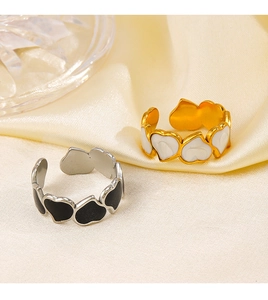 Detailed view of gold white and silver black heart rings on soft satin background