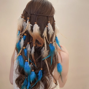 Detail eines Boho-Haarbandes mit blau-weißen Federn, Holzperlen und gewebter brauner Kordel