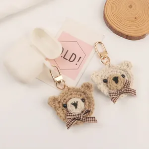 Cute crochet bow-tie bear keychain accessories in dark brown and cream colors with gold hooks