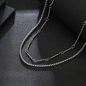 Detailed close-up of double layer silver box chain and twisted rope necklace textures