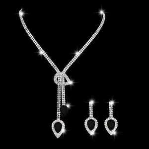 Dettaglio parure in argento con frange di cristallo e pietre a goccia nere su sfondo nero