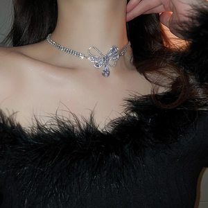 Close-up of sparkling cubic zirconia butterfly necklace with water drop pendant on neck