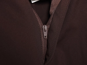 Close-up of a high-quality metal zipper and fabric texture on dark brown trousers