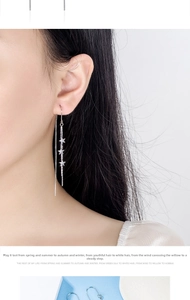 Close-up of elegant star tassel drop earrings with frosted stars on a slender chain