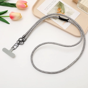 Detailed view of grey woven phone lanyard with metal clasp on a stylish white desk