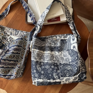Flat lay of bohemian linen tote bags with paisley patterns on a vintage wooden table