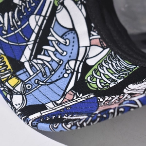 Macro detail of cartoon sneaker print on cotton canvas cap brim with precise stitching