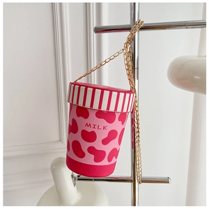 Detail of creative milk cup crossbody bag featuring red cow spots and gold chain strap