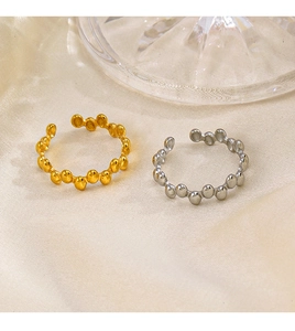Detail of adjustable gold and silver geometric oval rings on beige silk background