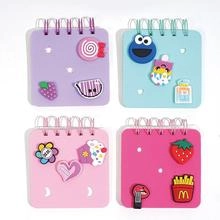 Detail view of 4 mini spiral notebooks with 3D cartoon resin charms in diverse colors