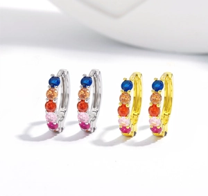 Macro detail of silver and gold hoop earrings featuring five vibrant multi-color zircon stones