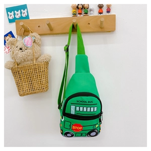 Detail of green canvas kids school bus chest bag hanging on a wooden hook