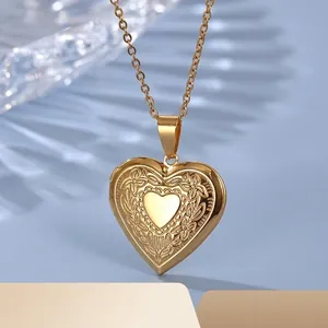 Gold stainless steel heart locket necklace with floral engraving on light blue background