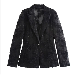 Détail d'un blazer noir en dentelle transparente avec fleurs 3D et paillettes fines