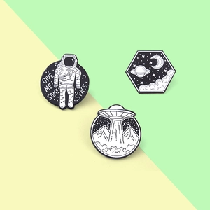 Détail de trois épingles en émail avec astronaute, OVNI et lune étoilée