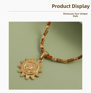 Détail d'un pendentif soleil doré vintage avec chaîne perlée marron et métal doré