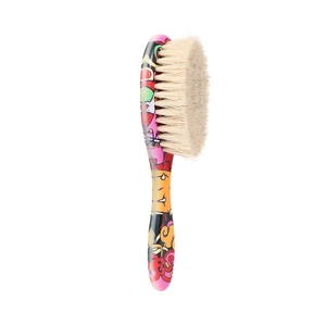 Close-up of baby hairbrush with natural bristles and colorful cartoon monster pattern