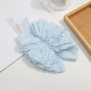 Elegant light blue pleated bow hair clip with faux pearls for women in a lifestyle setting