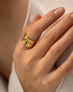 Detail eines breiten 18K Gold-Edelstahlrings mit bunten Zirkonia auf Hammerschlag-Textur
