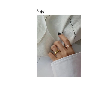 Detail of two gold plated sterling silver rings with lava texture and oval stone inlay