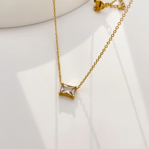 Detailed view of square-cut zircon pendant on gold-plated thin chain necklace