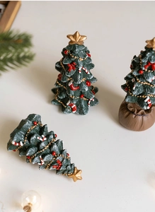 Detail view of resin Christmas tree with red bow, candy cane and golden star topper