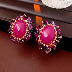 Close-up of vintage oval pink stone earrings with purple beads and gold metal finish
