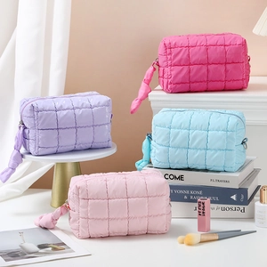 Detailed view of quilted nylon makeup bags in four pastel colors with bow zippers